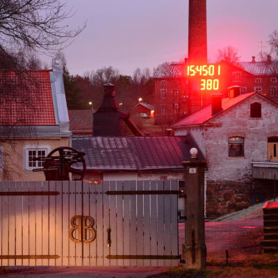 Porten till Billnäs bruk där en röd, stor digital klocka finns.