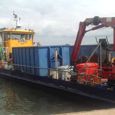 M/s Bordö tömmer avfall från Sandö i Lovisa