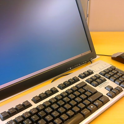På bilden syns en del av en datorskärm, en del av ett tangentbord och datormusen.