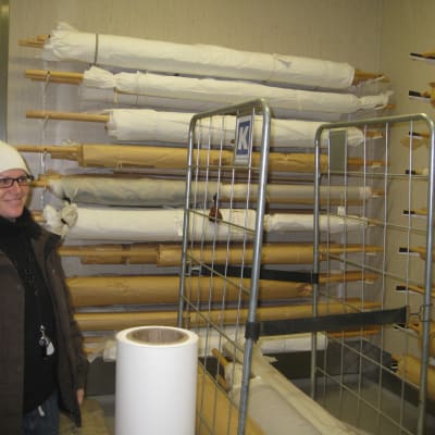 föremålsforskare lena dahlberg invid textilier på rulle