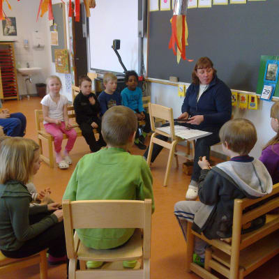 Barn som sitter i en ring i förskolan.