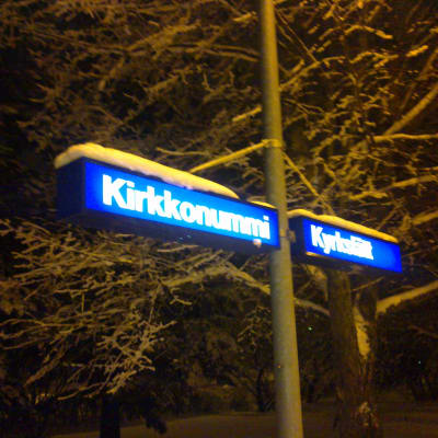 Ortnamnsskylt på Kyrkslätt station i vintertid.