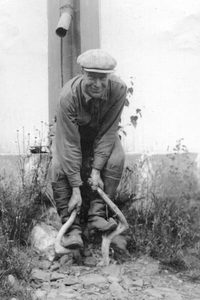 En man leker leken "gå på skakokäppar", som är ungefär samma som att gå på styltor. Bilden är tagen 1932 i Esse.