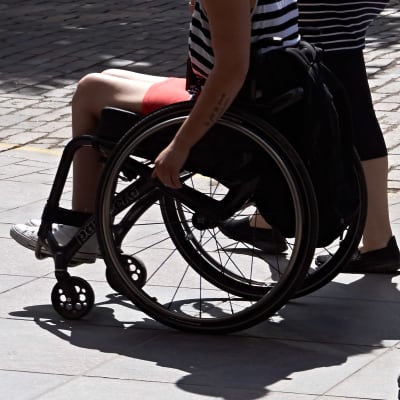 En rullstolsburen person syns bland människor som är ute och går.