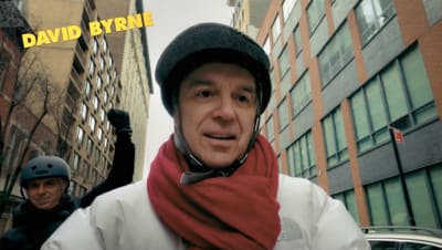 David Byrne pyöräilykypärä päässä kadulla.