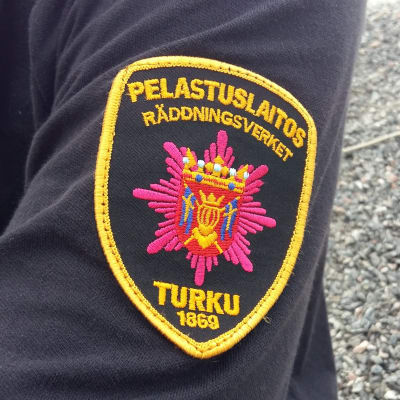Närbild av ärmen på en brandman, räddningsverkets logga är insydd i skjortan. 