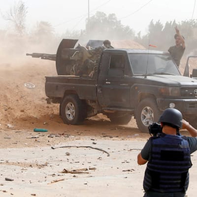 En journalist fotograferar striderna i utkanten av Libyens huvudstad Tripoli