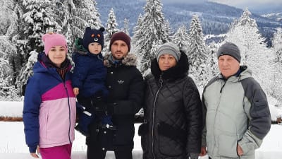 En bror och syster och deras föräldrar i ett vinterlandskap i västra Ukraina. Brodern har sitt barn i famnen.
