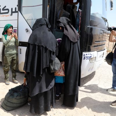 Kvinnor stiger ombord på en buss i al-Hol-lägret i Syrien.