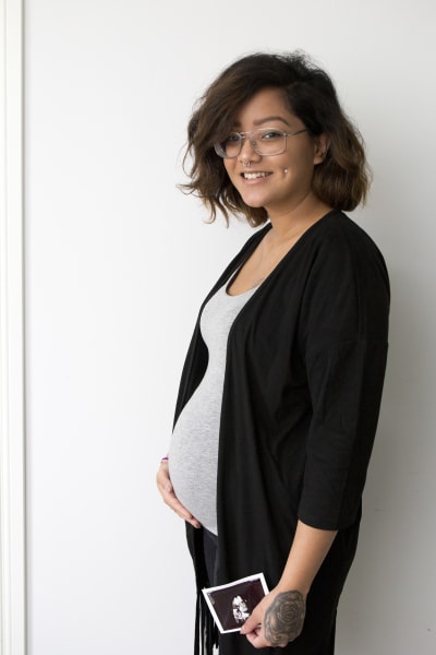 Emilia Jansson håller i en ultraljudsbild av sin bebis. Hon håller totot mot magen. 