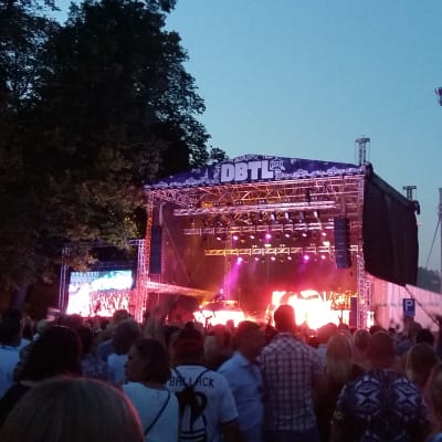 Huvudscenen på musikfestivalen Down By The Laituri i Åbo där bokstäverna DBTL lyser i sommarskymningen.