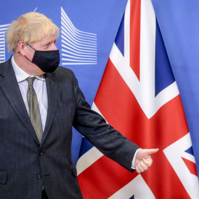 Storbritanniens premiärminister Boris Johnson och EU-kommissionens ordförande Ursula von der Leyen tittar mot varandra. Johnson står framför Storbritanniens flagga, von der Leyen framför EU:s flagga. Johnson visar tummen upp. Bilden tagen 9.12.2020.