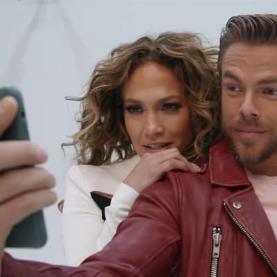 Jennifer Lopez ja Derek Hough poseeraavat kännykän edessä.