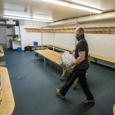 KalPan huoltaja Mika Hirvinen tuo vissypulloja pukukoppiin.