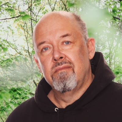 Marcus Rosenlund ser rakt in i kameran. I bakgrunden syns grönskande buskar.