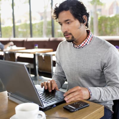 Mies kahvilassa työskentelee tietokoneella