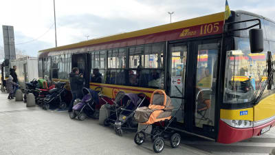 En buss med ett tiotal barnvagnar utanför.