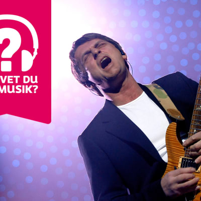 Mike Oldfield blundar och grimaserar och spelar elgitarr.