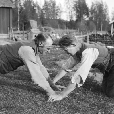 Två män leker leken "dra pissmyra". Bilden är tagen 1929 i Strömfors, Kejtala.