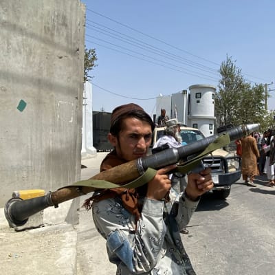 Taliban sotilas pitää raketinheitintä kädessään Afganistanin sisäministeriön edessä Kabulissa.