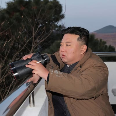 Pohjois-Korean johtaja Kim Jong-unin sormien välissä palava tupakka kiikaroidessaan parvekkeella.