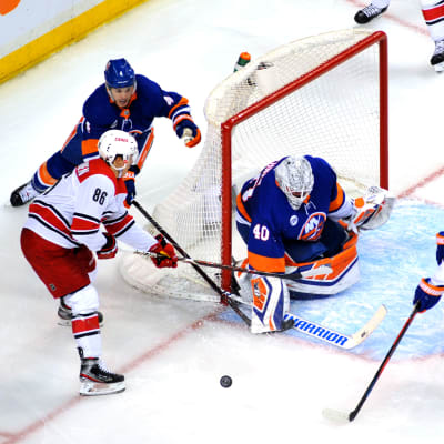 Carolinas Teuvo Teräväinen kämpar om pucken framför Robin Lehner i Islandersmålet.