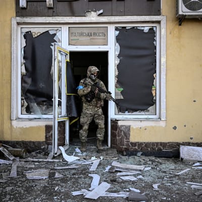 Ukrainalaissotilas kävelee ulos tuhoutuneesta rakennuksesta Mariupolissa.