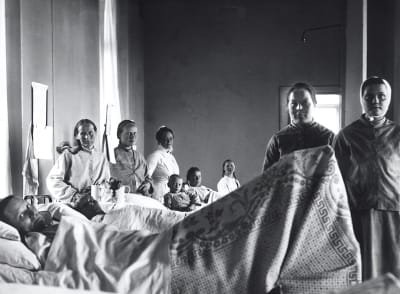 Kvinnos ligger i sina sängar i en sjukhussal år 1905
