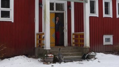 Jon LIndström vid ytterdörren till en gammal skola, numera hem och kursgård. Vinter
