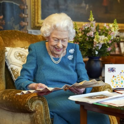 Kuningatar Elisabet II tutki hymyillen muistoja menneiltä juhlavuosilta perjantaina.