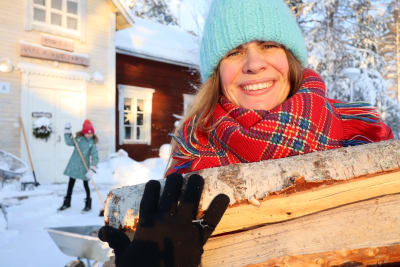Inari Fernandez kantaa puita talonsa edustalla Sodankylässä