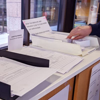 Te-toimiston aulassa on lomakkeita ja kirjekuoria, joilla voi ilmoittautua työttömäksi työnhakijaksi.