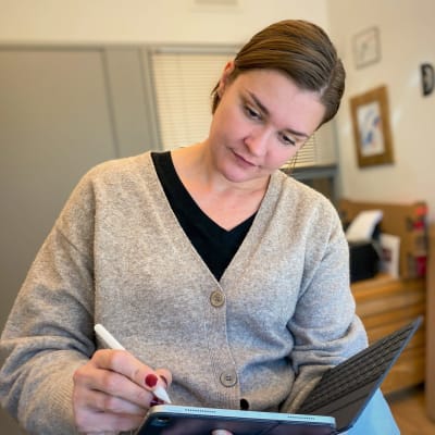 Maria Sannström illustrerar i sitt arbetsrum. 