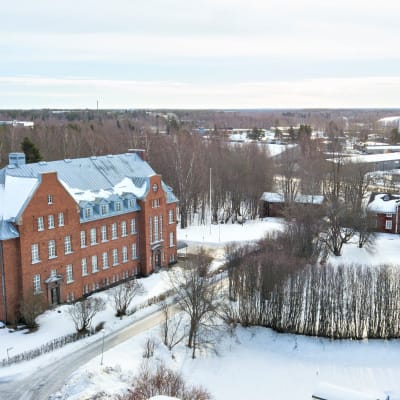 Huutokaupattavana olevia rakennuksia talvisessa luonnossa 