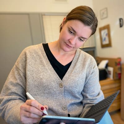 Maria Sannström illustrerar i sitt arbetsrum. 
