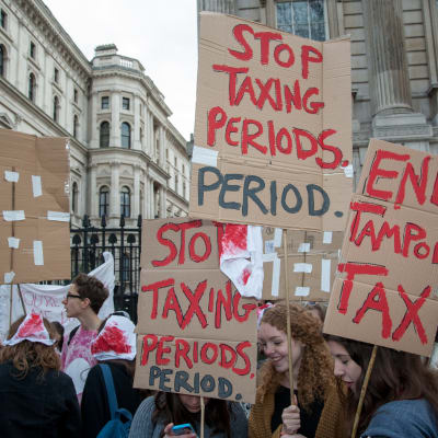 Naiset pitelevät kylttejä, joissa lukee muun muassa "Stop taxing periodes. Period."