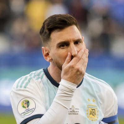 Lionel Messi håller för sin mun.