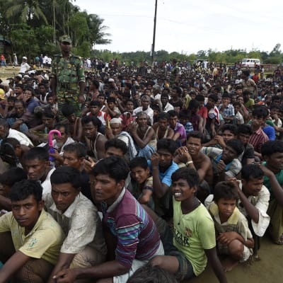 Burmesiska Rohingya-flyktingar väntar på mat i ett flyktingläger i Bangladesh.