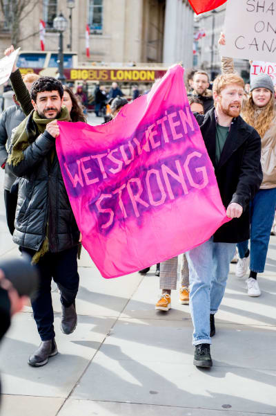 Demonstranter med en skylt där det står "Wetsuweten Strong"