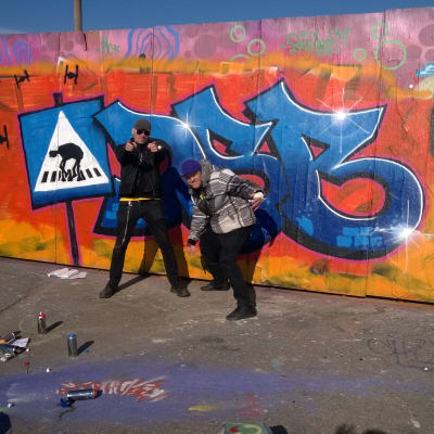 Lasse grönroos och theo sandström framför graffitivägg
