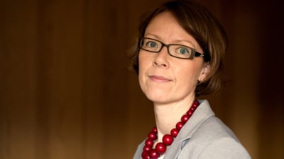 Cataharina Groop poserar framför en brun bakgrund.