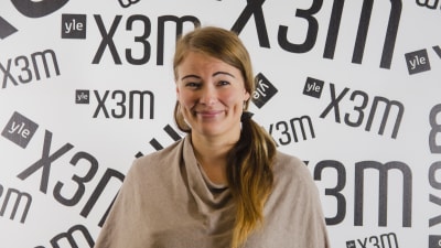 Sofia Syrjänen står mot en vägg.