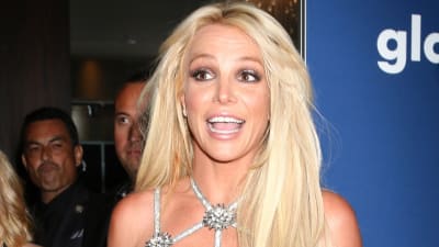 Britney Spears ler och poserar på röda mattan.