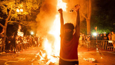 Demonstrant framför eld.