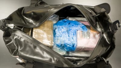 En väska innehållande flera kilo kokain och hasch. Polisen beslagtog väskan i ett grådshus i en hyresstuga i april 2019.