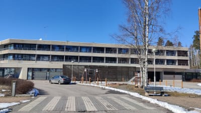En betongbyggnad i två våningar med många fönster där det finns hotell.