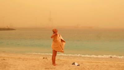 Kvinna vid stranden i sandstorm på Kanarieöarna