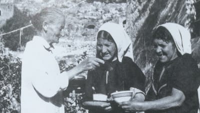 Hilma Granqvists sageskvinnor Sitt Louisa, Alya Ibrahim och Hamdiya Sanad i byn Artas i Palestina. Här delar Sitt Louisa ut socker till Alya och Hamdiya. I förgrunden syns Hilmas egen skugga, som den ofta gjorde på hennes fotografier.