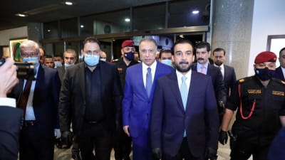 Iraks nya premiärminister Mustafa Kadhemi (i blått i mitten) anländer till förtroendeomröstningen i parlamentet. 