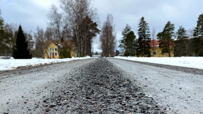 Grusväg som leder till ett gult hus.